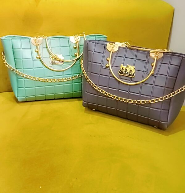 Turquoise quilted handbag with gold chain accents placed on a yellow background