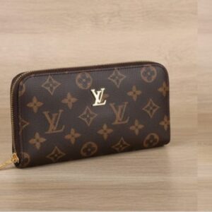 Louis Vuitton Brown Monogram Wallet held in hand with classic logo design