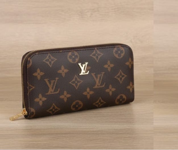 Louis Vuitton Brown Monogram Wallet held in hand with classic logo design