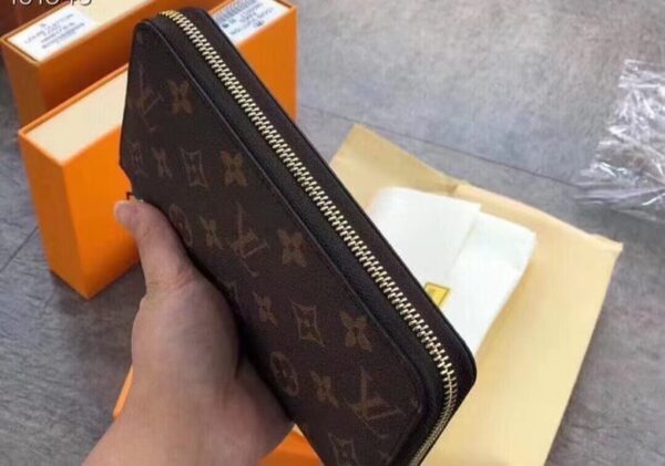 Louis Vuitton Brown Monogram Wallet held in hand with classic logo design