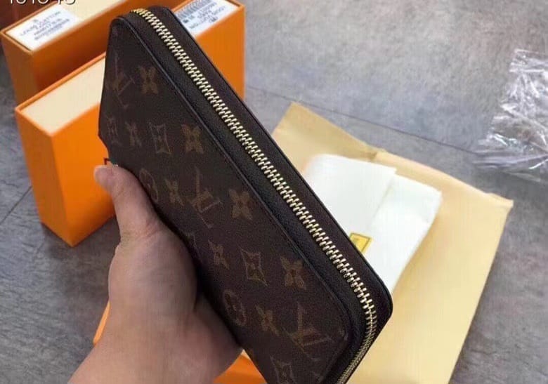 Louis Vuitton Brown Monogram Wallet held in hand with classic logo design